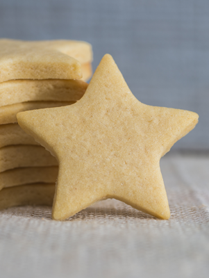 a stack of star-shaped sugar cookies with one propped up on the side
